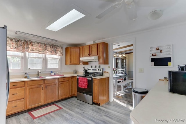 9361 Sheldon Ln, Gloucester, VA 23061 - kitchen featuring stainless steel appliances, light countertops, under cabinet range hood, a sink, and light wood-type flooring