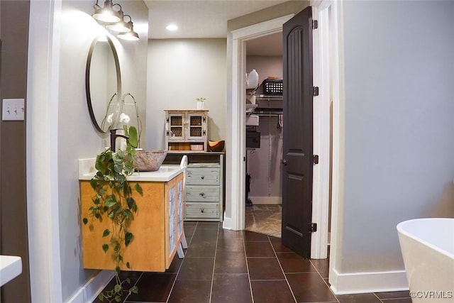 6420 Clayville Ln, Moseley, VA 23120 - full bathroom with baseboards, vanity, a freestanding bath, a walk in closet, and tile patterned flooring