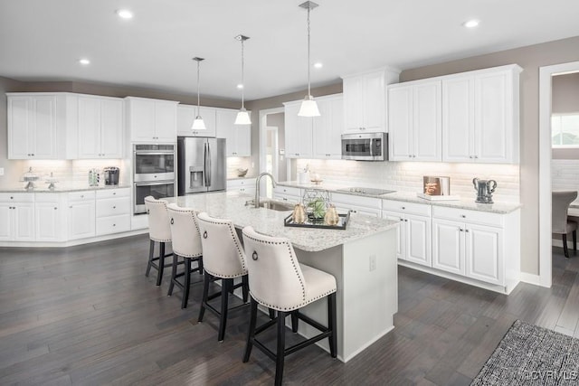 13006 Abercrombie Dr, Chesterfield, VA 23838 - kitchen with appliances with stainless steel finishes, backsplash, recessed lighting, a breakfast bar, and white cabinets