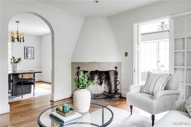 4318 Stuart Ave, Richmond, VA 23221 - living area featuring wood finished floors, arched walkways, a chandelier, and baseboards