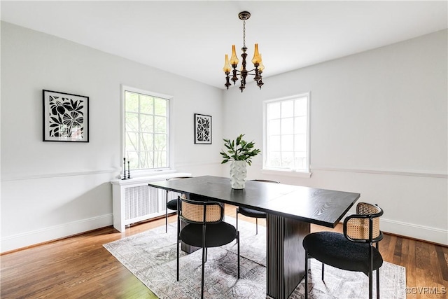 4318 Stuart Ave, Richmond, VA 23221 - dining room with a chandelier, wood finished floors, baseboards, and radiator