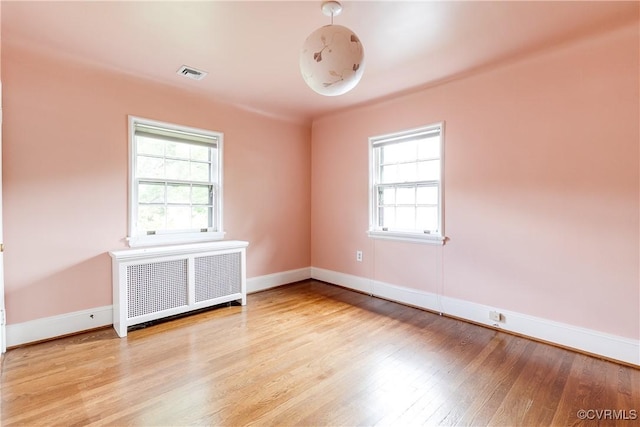 4318 Stuart Ave, Richmond, VA 23221 - unfurnished room featuring radiator heating unit, healthy amount of natural light, wood finished floors, and baseboards
