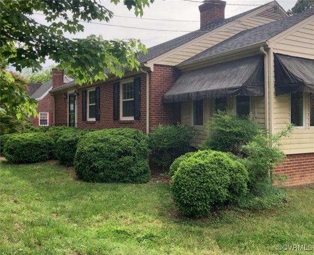726 S Broad St, Kenbridge, VA 23944 - view of property exterior with a chimney, brick siding, and a yard