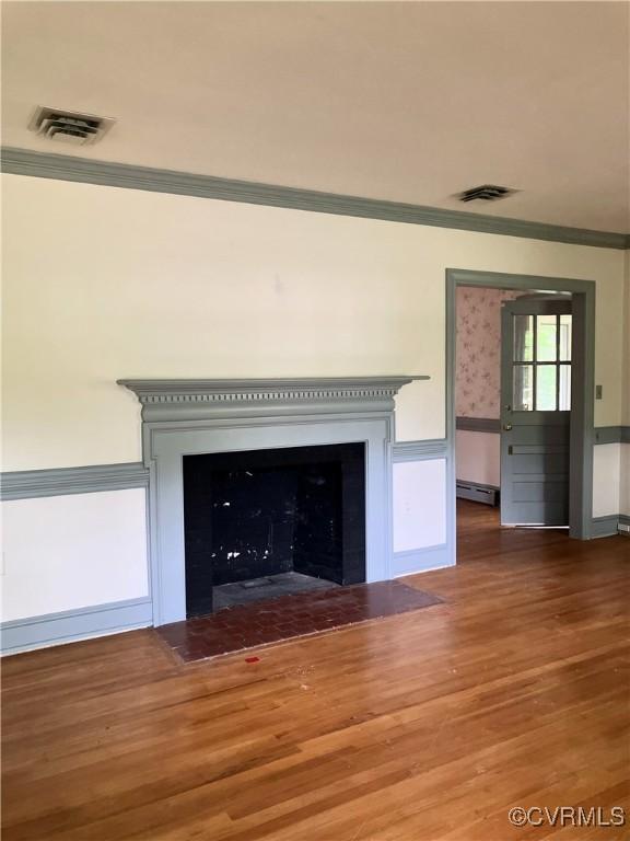 726 S Broad St, Kenbridge, VA 23944 - detailed view of crown molding, a baseboard heating unit, wood finished floors, and a fireplace with flush hearth