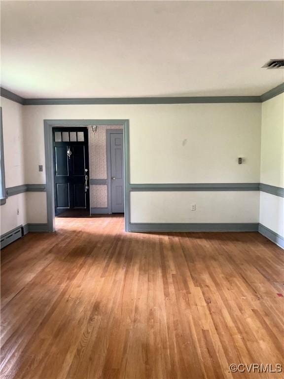 726 S Broad St, Kenbridge, VA 23944 - unfurnished room with ornamental molding, wood finished floors, baseboards, and a baseboard heating unit