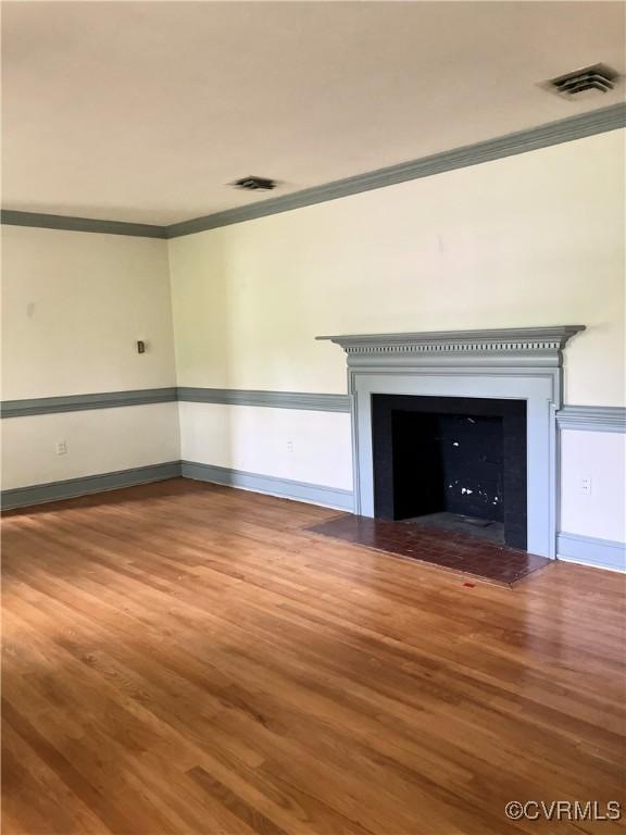 726 S Broad St, Kenbridge, VA 23944 - unfurnished living room featuring a fireplace with flush hearth, ornamental molding, wood finished floors, and baseboards