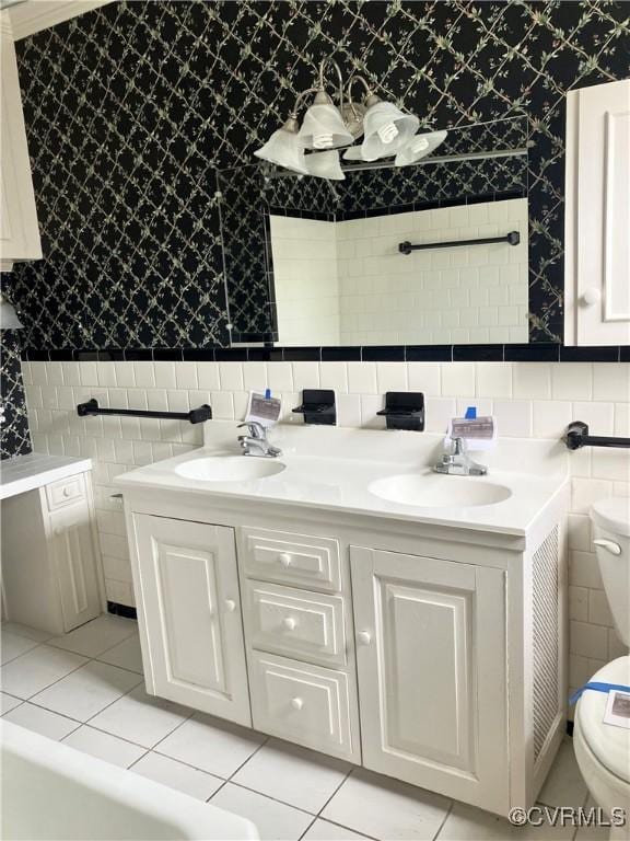726 S Broad St, Kenbridge, VA 23944 - bathroom featuring tile walls, toilet, wallpapered walls, double vanity, and tile patterned flooring