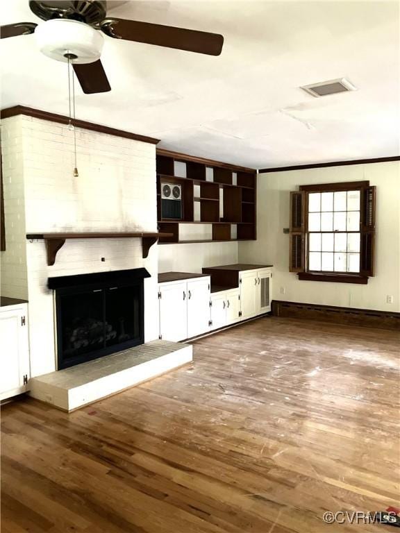 726 S Broad St, Kenbridge, VA 23944 - unfurnished living room featuring ceiling fan, wood finished floors, a fireplace, and crown molding