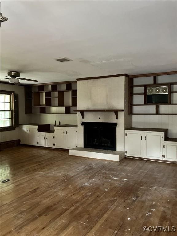 726 S Broad St, Kenbridge, VA 23944 - unfurnished living room with dark wood finished floors, ceiling fan, and a large fireplace