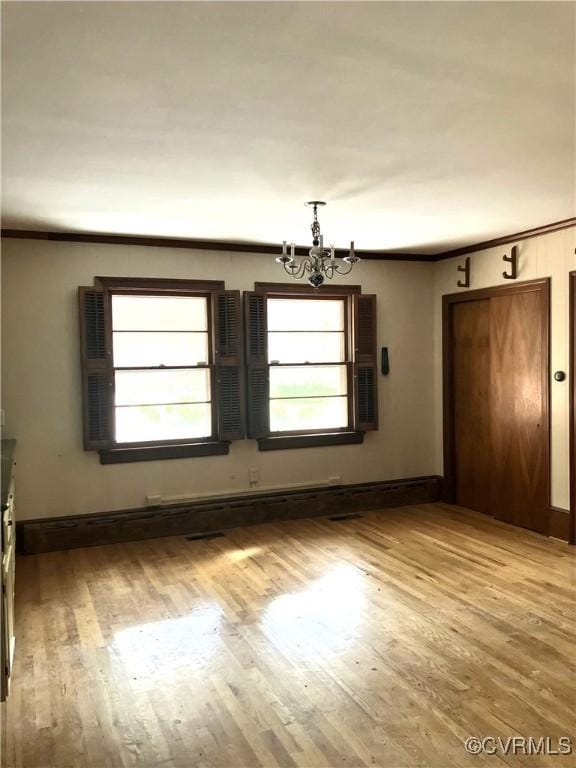 726 S Broad St, Kenbridge, VA 23944 - unfurnished dining area with a chandelier, light wood-style floors, crown molding, and baseboards
