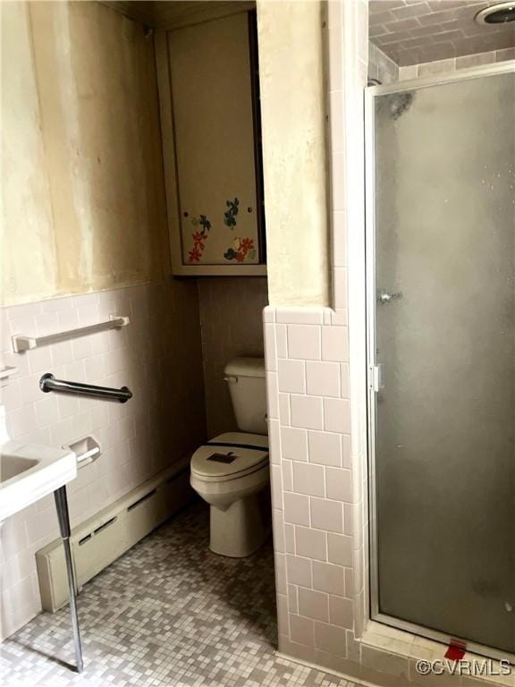 726 S Broad St, Kenbridge, VA 23944 - bathroom with tile walls, a shower stall, toilet, a baseboard radiator, and a wainscoted wall