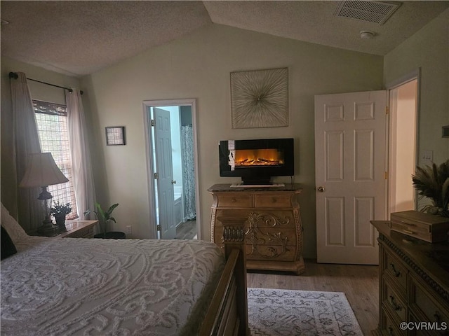 6778 Sassafras Dr, Quinton, VA 23141 - bedroom featuring vaulted ceiling, light wood-style flooring, and a glass covered fireplace