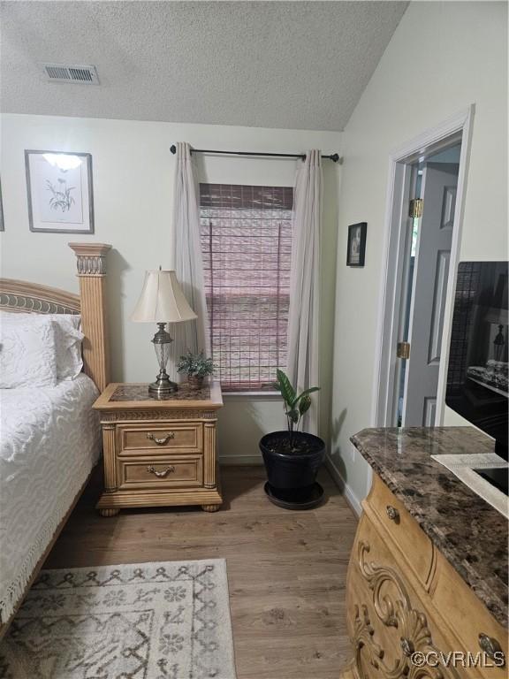6778 Sassafras Dr, Quinton, VA 23141 - bedroom with vaulted ceiling, light wood-style flooring, a textured ceiling, and baseboards