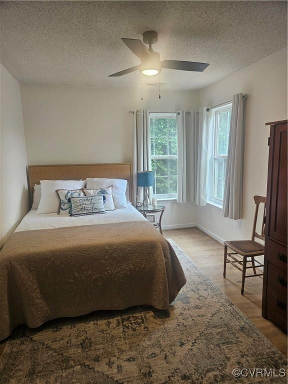6778 Sassafras Dr, Quinton, VA 23141 - bedroom featuring light wood-type flooring, a textured ceiling, a ceiling fan, and baseboards