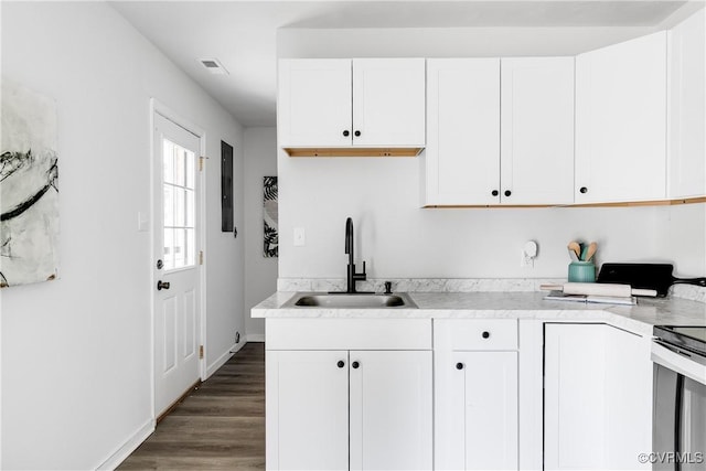 2222 Binford Ln, Richmond, VA 23223 - kitchen with a sink, range with electric stovetop, light countertops, and white cabinetry