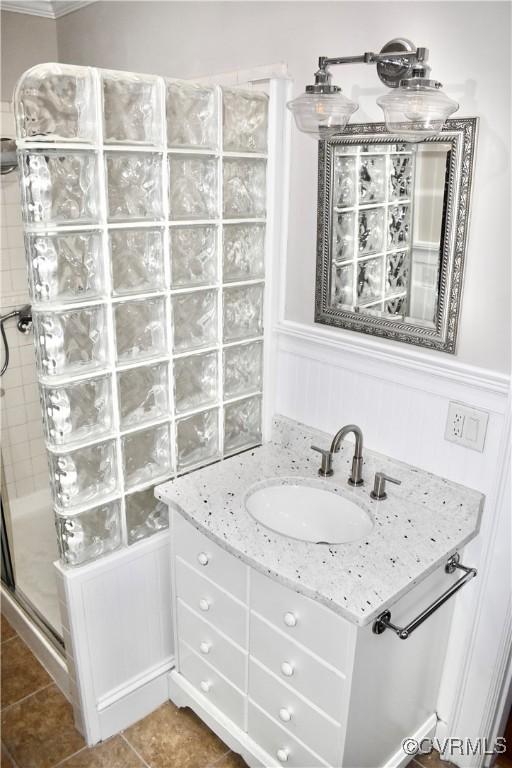 2923 Monument Ave Unit 1, Richmond, VA 23221 - bathroom featuring vanity, a shower stall, tile patterned floors, and wainscoting