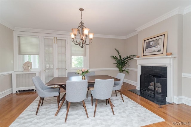 2923 Monument Ave Unit 1, Richmond, VA 23221 - dining room featuring light wood-style floors, a chandelier, crown molding, baseboards, and a fireplace