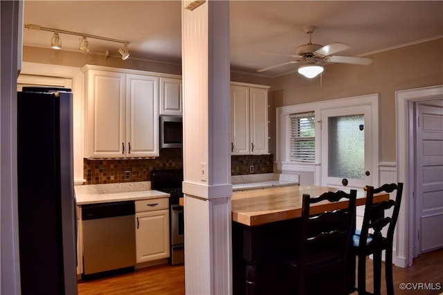 2923 Monument Ave Unit 1, Richmond, VA 23221 - kitchen with appliances with stainless steel finishes, butcher block counters, backsplash, white cabinets, and a ceiling fan