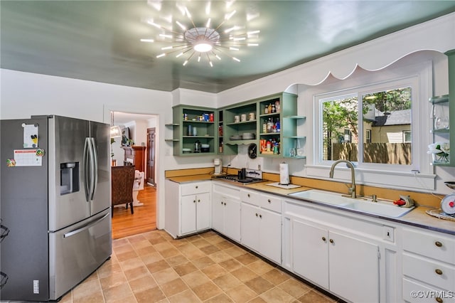 1743 Johnson Rd, Petersburg, VA 23805 - kitchen featuring stainless steel fridge, a sink, open shelves, white cabinets, and a chandelier
