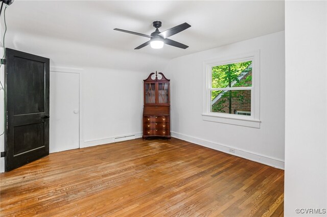 1743 Johnson Rd, Petersburg, VA 23805 - unfurnished bedroom with wood finished floors, a baseboard heating unit, a ceiling fan, and baseboards