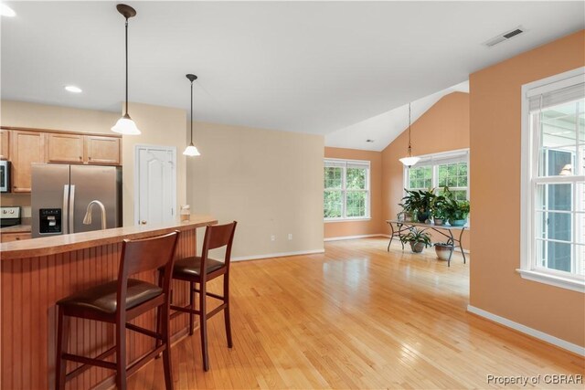 3907 Currier Ct, Chester, VA 23831 - kitchen with stainless steel appliances, baseboards, light wood-style floors, a breakfast bar area, and vaulted ceiling