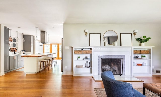 1708 Michaels Rd, Henrico, VA 23229 - living room with light wood finished floors, baseboards, a fireplace with raised hearth, and built in shelves