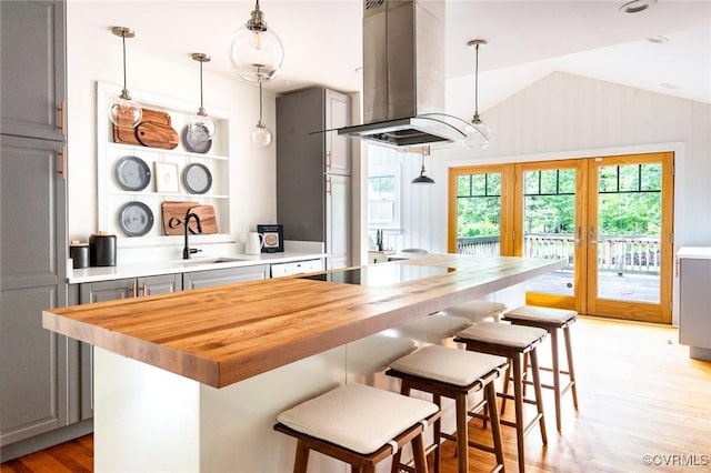 1708 Michaels Rd, Henrico, VA 23229 - kitchen with island exhaust hood, butcher block counters, a sink, light wood-type flooring, and vaulted ceiling