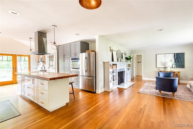 1708 Michaels Rd, Henrico, VA 23229 - kitchen featuring stainless steel appliances, island exhaust hood, wooden counters, light wood-type flooring, and decorative light fixtures