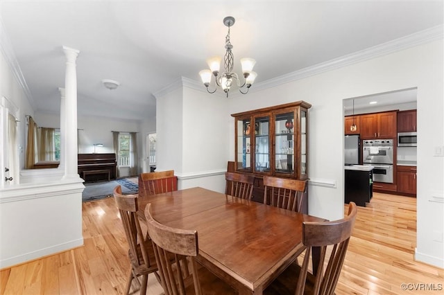 15836 Hampton Park Cir, Chesterfield, VA 23832 - dining space with light wood-type flooring, crown molding, a chandelier, decorative columns, and a fireplace