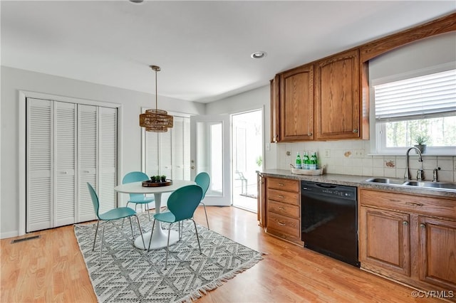 7611 Comanche Dr, Richmond, VA 23225 - kitchen featuring black dishwasher, a sink, brown cabinets, decorative backsplash, and light wood-type flooring