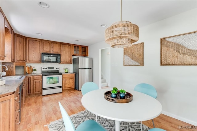 7611 Comanche Dr, Richmond, VA 23225 - kitchen featuring stainless steel appliances, a sink, brown cabinets, light wood-style flooring, and recessed lighting