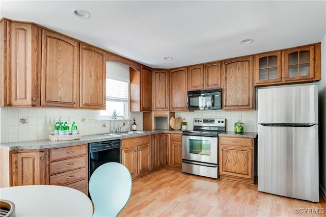 7611 Comanche Dr, Richmond, VA 23225 - kitchen with black appliances, a sink, tasteful backsplash, brown cabinets, and recessed lighting