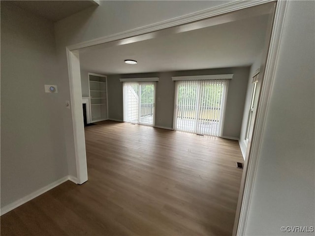7821 Breaker Point Ct, Chesterfield, VA 23832 - spare room featuring baseboards, wood finished floors, a fireplace, and built in shelves