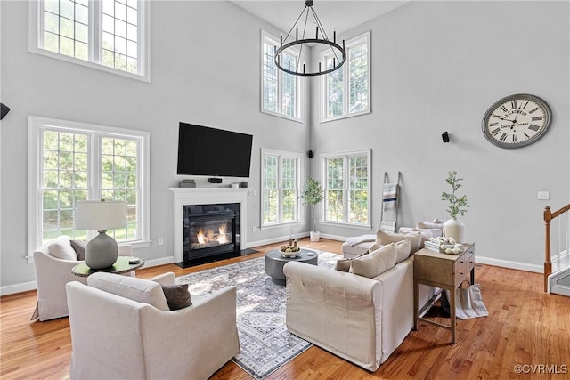 14136 Rigney Dr, Midlothian, VA 23113 - living area featuring plenty of natural light, a towering ceiling, a chandelier, and light wood-type flooring