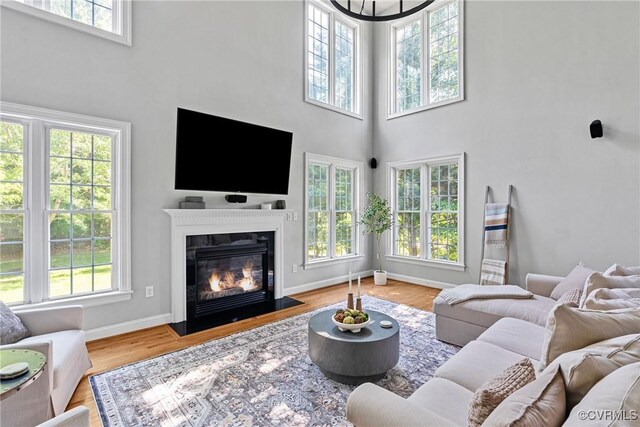 14136 Rigney Dr, Midlothian, VA 23113 - living room featuring a high ceiling, a fireplace with flush hearth, baseboards, and wood finished floors