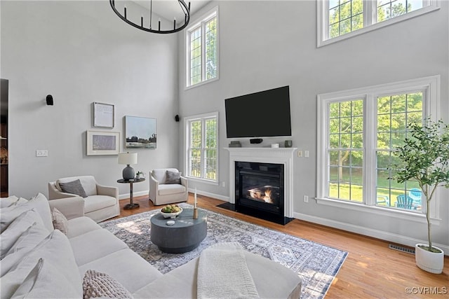 14136 Rigney Dr, Midlothian, VA 23113 - living area with a towering ceiling, healthy amount of natural light, baseboards, a fireplace with flush hearth, and wood finished floors