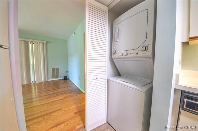 54 Villa Ridge Dr Unit C, Hartfield, VA 23071 - washroom with stacked washer / dryer, light wood-style floors, and baseboards