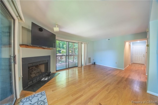 54 Villa Ridge Dr Unit C, Hartfield, VA 23071 - unfurnished living room with a fireplace with flush hearth, wood finished floors, and baseboards