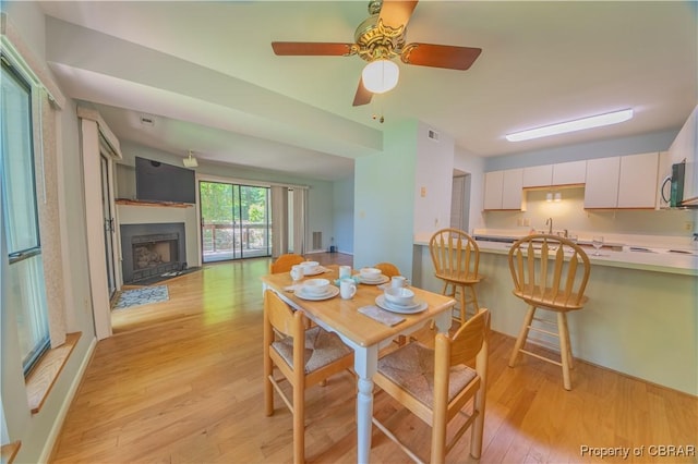 54 Villa Ridge Dr Unit C, Hartfield, VA 23071 - dining room featuring light wood-type flooring, a fireplace, and a ceiling fan