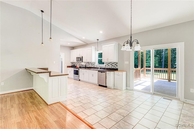 6180 Emmaus Church Rd, Providence Forge, VA 23140 - kitchen with stainless steel appliances, vaulted ceiling, decorative backsplash, a chandelier, and hanging light fixtures