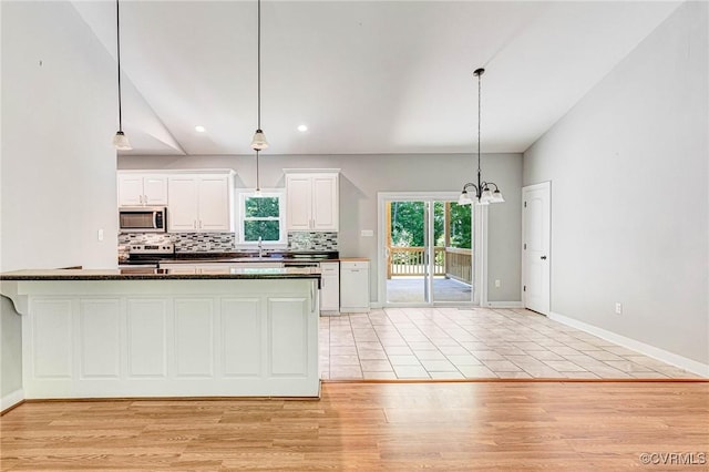 6180 Emmaus Church Rd, Providence Forge, VA 23140 - kitchen featuring appliances with stainless steel finishes, decorative backsplash, white cabinets, a chandelier, and light wood-style flooring
