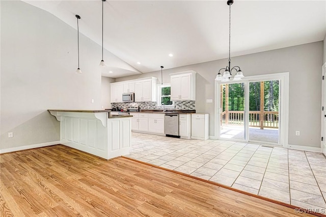 6180 Emmaus Church Rd, Providence Forge, VA 23140 - kitchen with lofted ceiling, dark countertops, tasteful backsplash, appliances with stainless steel finishes, and a chandelier