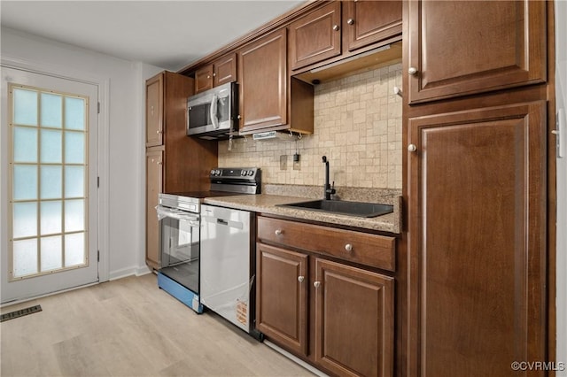 9901 Husting Ct, Chesterfield, VA 23832 - kitchen with appliances with stainless steel finishes, a sink, backsplash, light wood finished floors, and light countertops