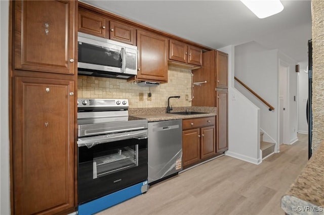 9901 Husting Ct, Chesterfield, VA 23832 - kitchen with stainless steel appliances, a sink, backsplash, light wood-style floors, and brown cabinets