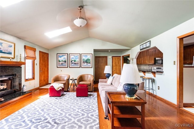 1412 Darrell Dr, Midlothian, VA 23114 - living area with wood finished floors, lofted ceiling, a tiled fireplace, and baseboards