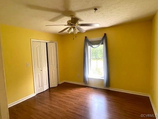 22290 Butterwood Rd, Dinwiddie, VA 23803 - unfurnished bedroom with dark wood finished floors, baseboards, a closet, and a ceiling fan