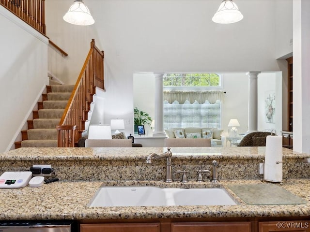 442 Dunlin Ct, Midlothian, VA 23114 - kitchen with decorative columns, a sink, open floor plan, a high ceiling, and light stone countertops