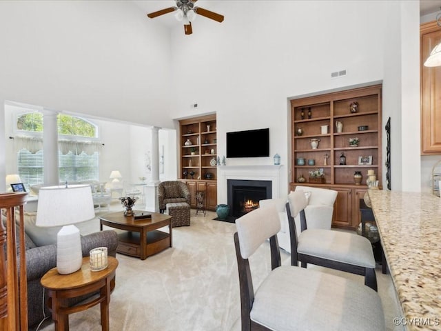 442 Dunlin Ct, Midlothian, VA 23114 - living room with a high ceiling, ornate columns, a fireplace with flush hearth, ceiling fan, and light carpet