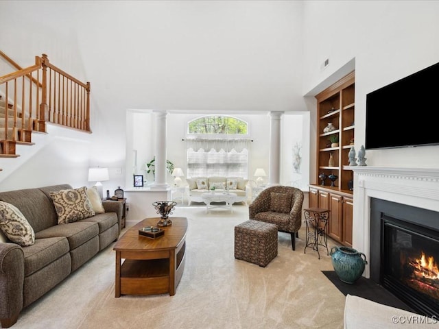 442 Dunlin Ct, Midlothian, VA 23114 - living room with a high ceiling, ornate columns, a fireplace with flush hearth, stairs, and light colored carpet