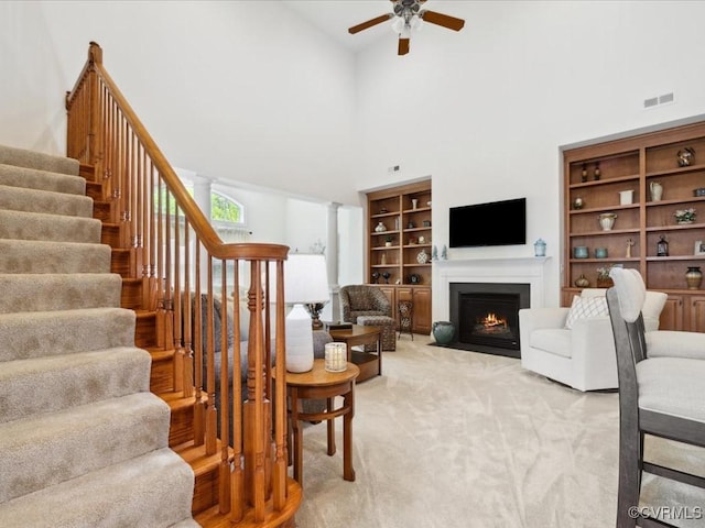 442 Dunlin Ct, Midlothian, VA 23114 - living room featuring stairway, a ceiling fan, a fireplace with flush hearth, a high ceiling, and light carpet